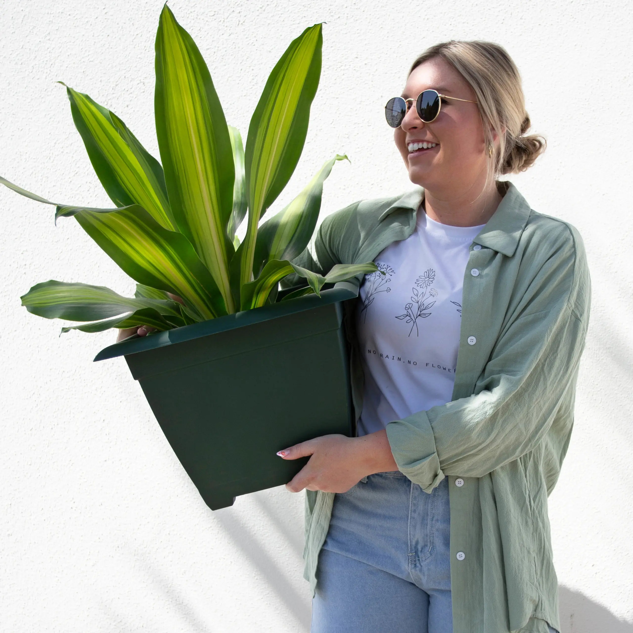 man holding blue pot with plant