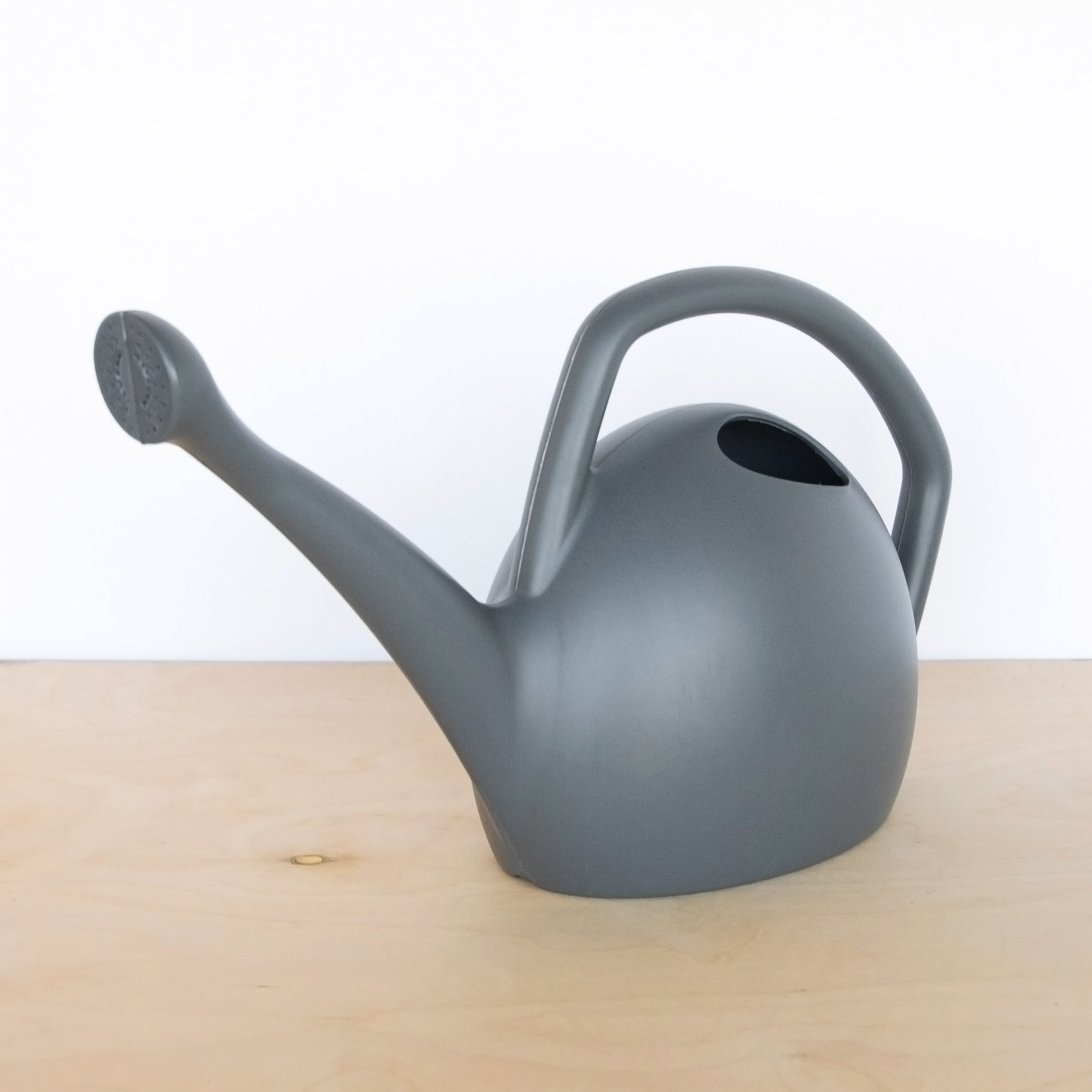 Gray, 2 gallon plastic watering can made from 100% recycled material. Attached spout and ergonomic handle.