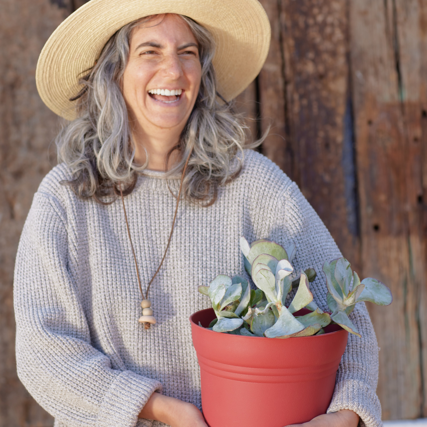 blonde woman holding potted plant
